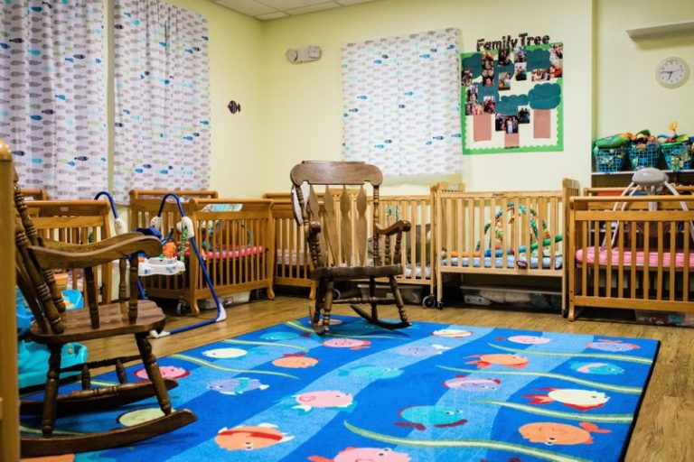 Nursery room with rocking chairs with cribs without babies at a Childcare Serving Branford & Wallingford, CT