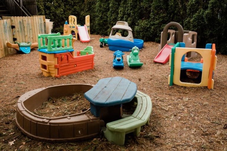 Colorful kids playground without the children, with slides , with plastic slides , bench and table and playhouse at a Childcare Serving Branford, Cheshire, Wallingford, CT