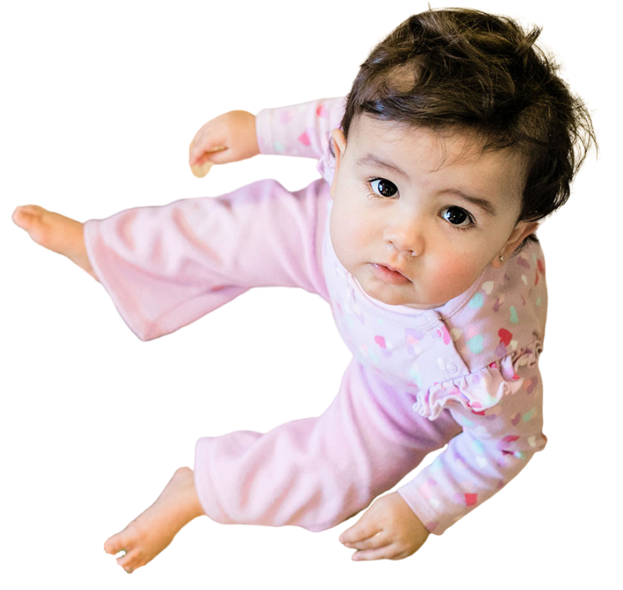 Adorable toddler girl sitting and wearing a pink pajama at a Childcare Serving Branford, Cheshire, Wallingford, CT